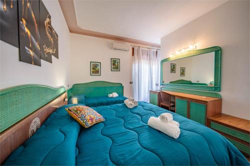 a bedroom with a blue bed and a mirror at SUITE APARTMENT TAORMINA in Taormina