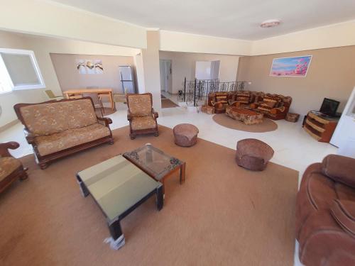 a living room with couches and chairs and a table at Hotel appartment sea view 3 bedrooms 3 toilets 4th floor Bellevue village agami alexandria families are preferred available all year days & 5 blankets available in Alexandria