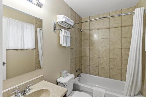 a bathroom with a tub and a toilet and a sink at Nights Inn Owen Sound in Owen Sound
