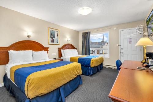 a hotel room with two beds and a table at Nights Inn Owen Sound in Owen Sound