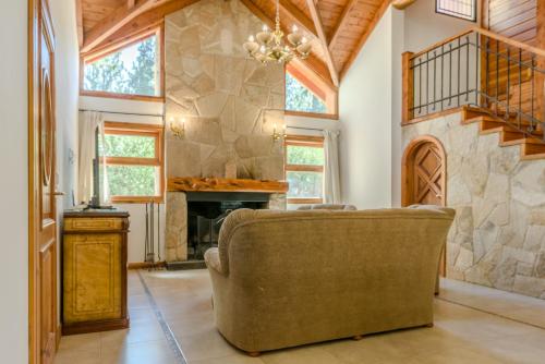 a living room with a couch and a stone fireplace at Casa en Bosque de Pinos in San Carlos de Bariloche