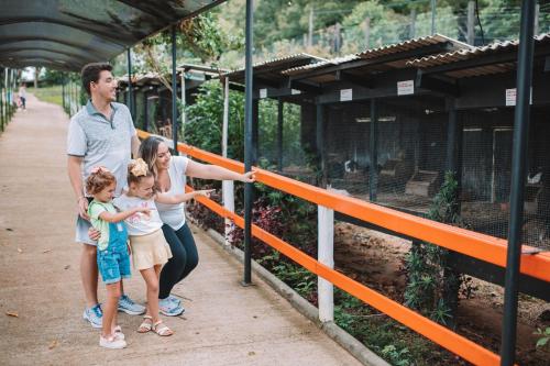 a man and a woman and two children looking at a zoo at Itá Thermas Resort e Spa in Itá