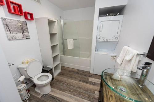e bagno con servizi igienici, doccia e tavolo in vetro. di Cottage Quebec - Olivine a Petite-Rivière-Saint-François