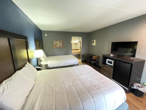 een slaapkamer met 2 bedden en een flatscreen-tv bij Econo Lodge in Forest City