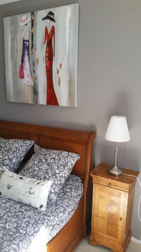 a bedroom with a bed and a painting on the wall at La Maison De Lena in Grézillac