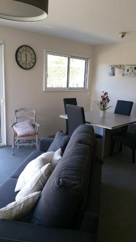 a living room with a couch and a table and a clock at La Maison De Lena in Grézillac