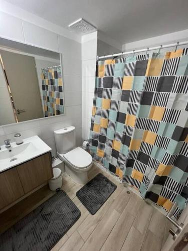 een badkamer met een toilet, een wastafel en een douche bij Depto Condominio Costa Pacifico in La Serena