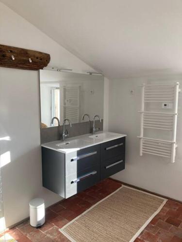 une salle de bain avec un lavabo et un miroir dans l'établissement L'Amelié, maison avec jardin en Provence, à Saint-Trinit