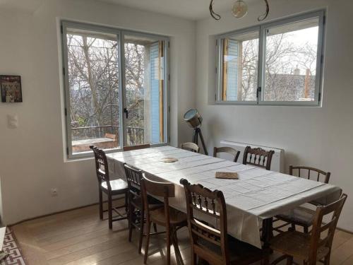 une salle à manger avec une table et des chaises blanches dans l'établissement L'Amelié, maison avec jardin en Provence, à Saint-Trinit