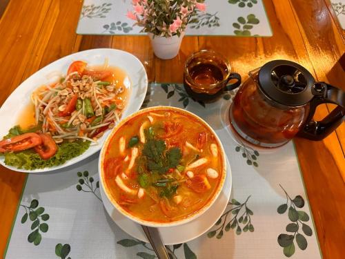 a table with two plates of food and a bowl of soup at BT hotel Kata Beach in Kata Beach