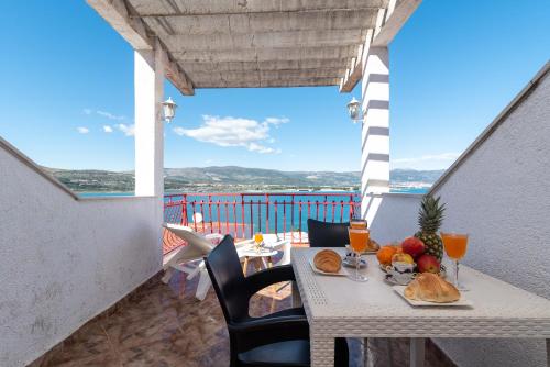 a table with food and drinks on a balcony at Aldino Rooms in Trogir