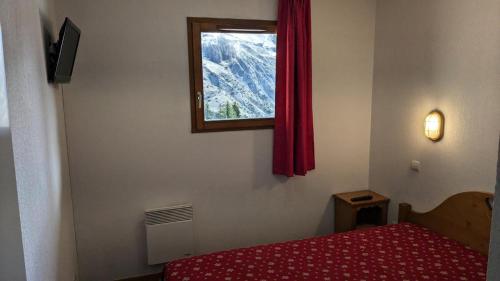 a bedroom with a red bed and a window at Résidence BALCONS DU SOLEIL - 3 Pièces pour 6 Personnes 404 in Orcières