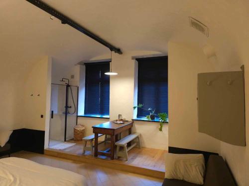 1 dormitorio con escritorio, 1 cama y ventanas en Erfgoedlogies Fort Liezele 