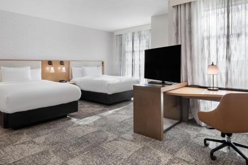 um quarto de hotel com duas camas e uma secretária com uma televisão em Residence Inn by Marriott Chatsworth em Chatsworth
