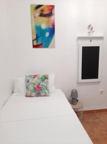 Una cama blanca con una almohada encima. en Habitación Avileña Tropical en Aguadulce en Almería