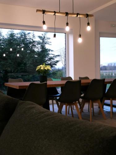 a dining room with a table and chairs and a large window at Ten Velde - vakantiewoning 12 personen - sauna - bubbelbad in Hoeselt
