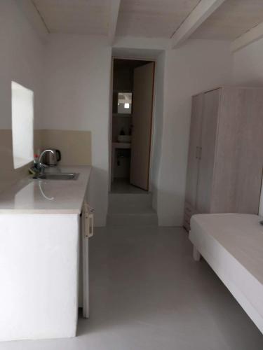 a kitchen with a sink and a bed in a room at Louloudas rooms paros in Molos Parou