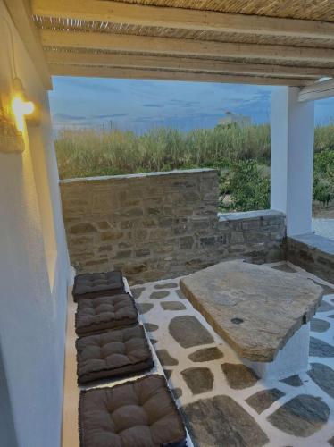 a patio with a bench and a stone wall at Louloudas rooms paros in Molos Parou