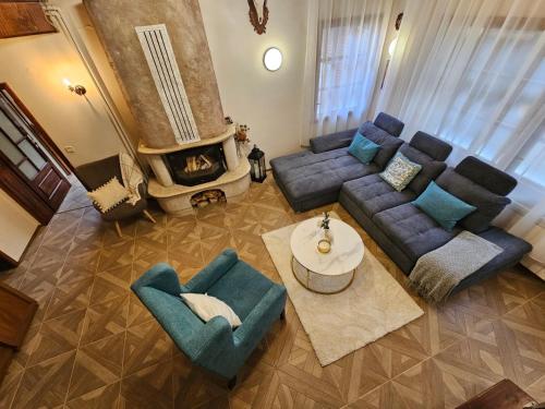 a living room with a couch and chairs and a fireplace at Вила Пенчеви, кк. Цигов чарк in Tsigov Chark