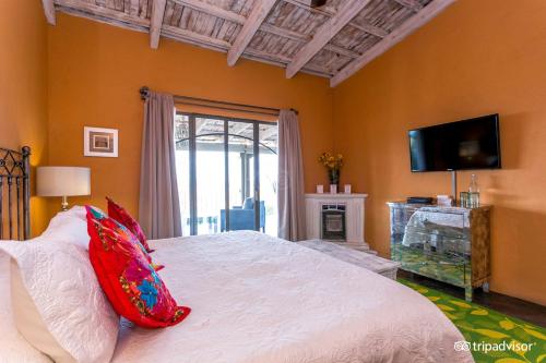 a bedroom with a bed with red pillows and a television at View Hotel Boutique in San Miguel de Allende