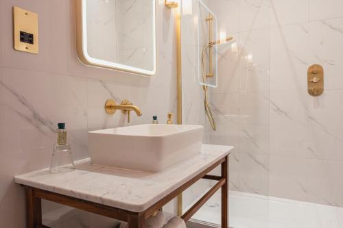 y baño blanco con lavabo y ducha. en Chris Wheeler at The Crown Inn en Buckinghamshire