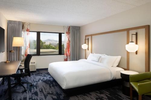 a hotel room with a white bed and a desk and a computer at Fairfield Inn & Suites by Marriott Denver Southwest/Lakewood in Lakewood
