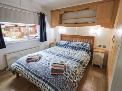 a bedroom with a bed with two bags on it at Lavender Lodge in Windermere