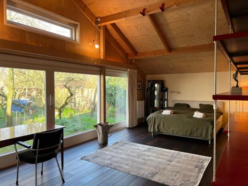 een slaapkamer met een bed en een groot raam bij Over Lake in Monnickendam