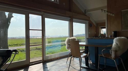 a room with a table and chairs and a large window at Over Lake in Monnickendam