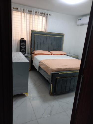 a bedroom with a large bed with orange pillows at Apartamento acogedor in Santiago de los Caballeros