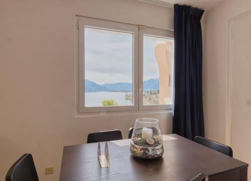 a dining room table with a view of a window at Casa Alla Roccabella in Minusio