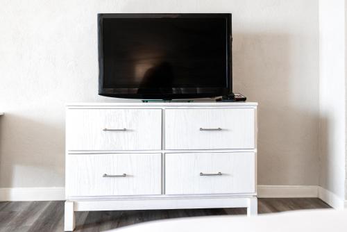 a white dresser with a television on top of it at Perry's Ocean-Edge Resort in Daytona Beach