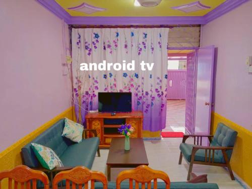 een woonkamer met een bank en een tv bij Gooday homestay in Skudai