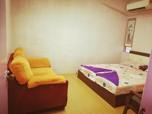 een kamer met een bed en een stoel. bij Gooday homestay in Skudai
