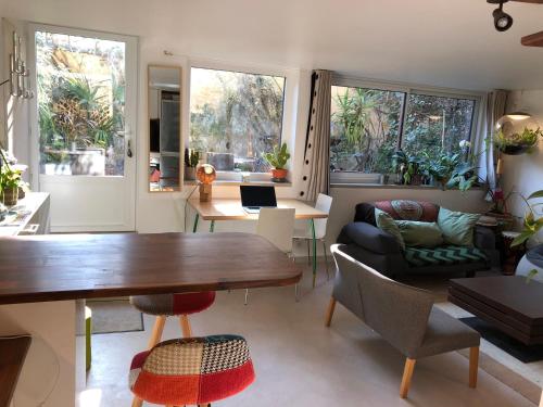 un salon avec une table et des chaises en bois dans l'établissement Charming house, calm garden in the center of Paris, à Paris