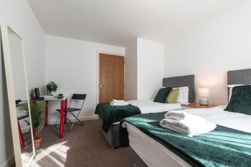 a hotel room with two beds and a desk at Accessible 2 bedrooms flat + P in Southampton