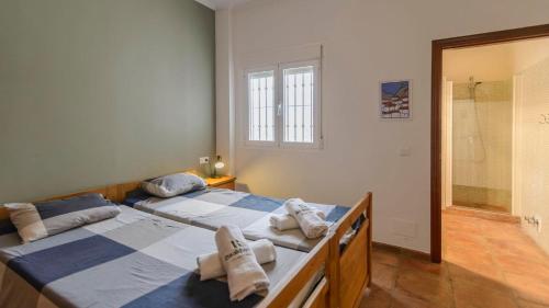 - 2 lits dans une chambre avec douche dans l'établissement Villa Bandoleros Arenas by Ruralidays, à Arenas