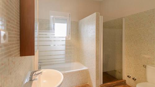 La salle de bains est pourvue d'une baignoire, d'un lavabo et d'une douche. dans l'établissement Villa Bandoleros Arenas by Ruralidays, à Arenas