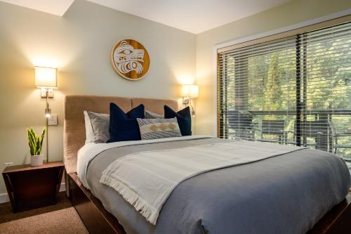 a bedroom with a large bed and a window at Steps to the Ski Hill with Rooftop Hot Tub by Harmony Whistler in Whistler