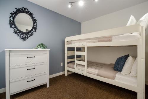 a white bunk bed in a room with a mirror at Steps to the Ski Hill with Rooftop Hot Tub by Harmony Whistler in Whistler