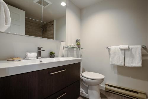 y baño con lavabo blanco y aseo. en Steps to the Ski Hill with Rooftop Hot Tub by Harmony Whistler, en Whistler