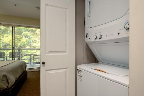 a kitchen with a stove and a washer and dryer at Steps to the Ski Hill with Rooftop Hot Tub by Harmony Whistler in Whistler