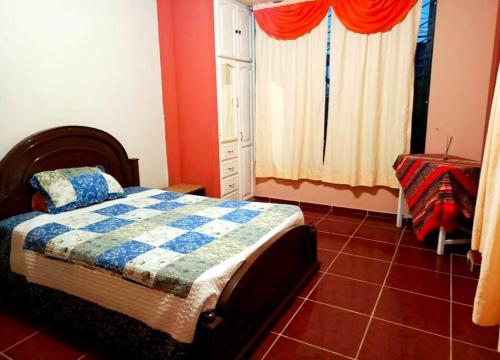- une chambre avec un lit et du carrelage rouge dans l'établissement Amplio y cómodo departamento con garage, à Puyo