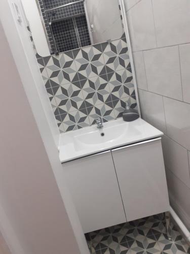 W łazience znajduje się umywalka i lustro. w obiekcie Maison Natis w mieście Tillé