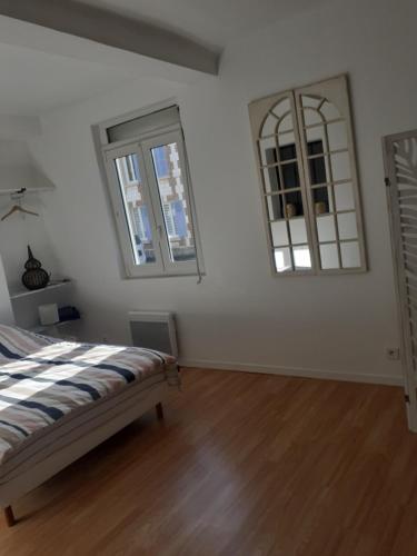 a bedroom with a bed and two mirrors on the wall at Maison Natis in Tillé