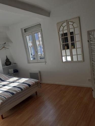 a bedroom with a bed and two mirrors on the wall at Maison Natis à 400 metres à pieds de l'aéroport in Tillé