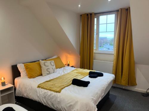 a bedroom with a bed with yellow curtains and a window at COSY 3 - City View in Sunderland