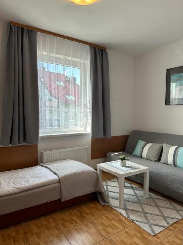 ein Wohnzimmer mit einem Sofa und einem Tisch in der Unterkunft Pensjonat Melodia in Pobierowo