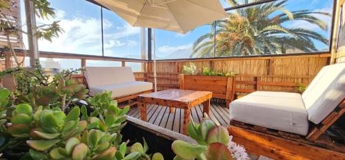 balcón con mesa, silla y sombrilla en Cabañas & Spa Qamawi, en Pan de Azúcar