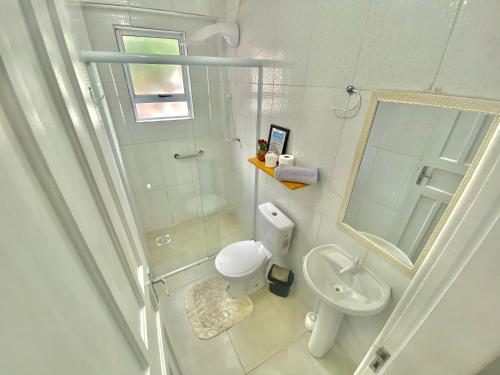 een badkamer met een toilet, een wastafel en een spiegel bij Apartamento Floripa 16 - Próximo Ao Centro, UFSC, Aeroporto e Praias in Florianópolis